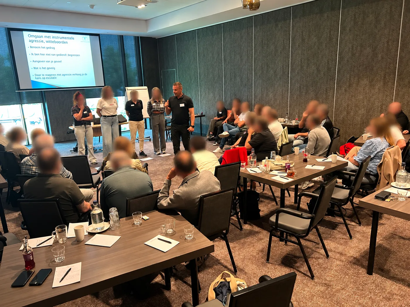Maikel geeft een training aan een volle zaal professionals